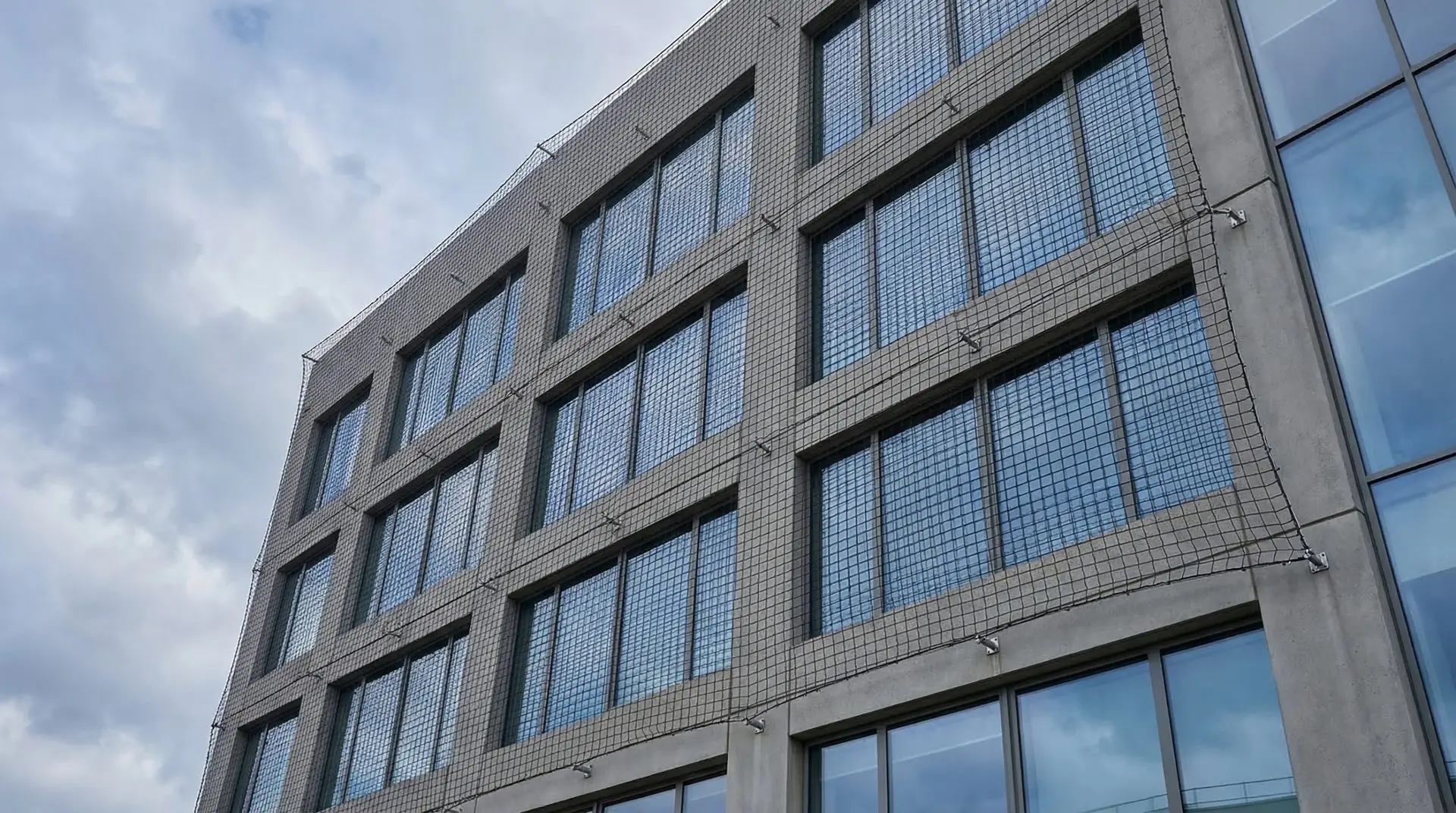 Vue architecturale d'un filet de protection installé sur la façade d'un immeuble de bureaux français
