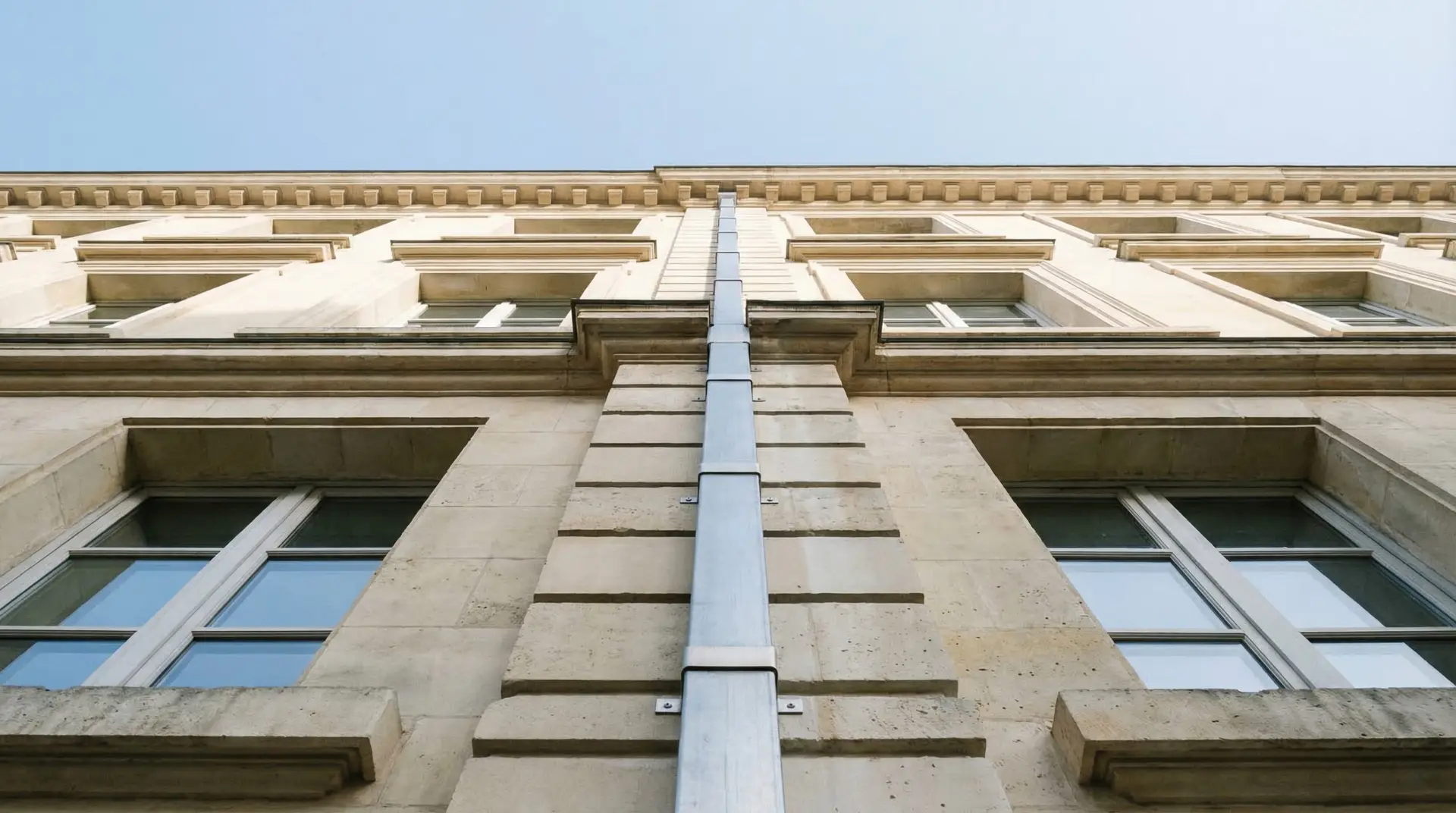 Nettoyage et réparation de gouttières inaccessibles sur façade d'immeuble classique