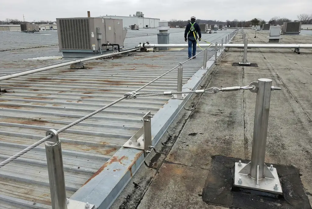 Ligne de vie permanente installée sur toit industriel avec points d'ancrage