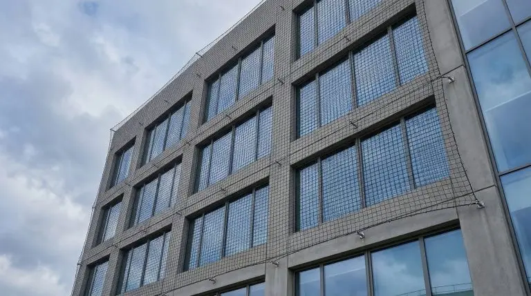 Vue architecturale d'un filet de protection installé sur la façade d'un immeuble de bureaux français